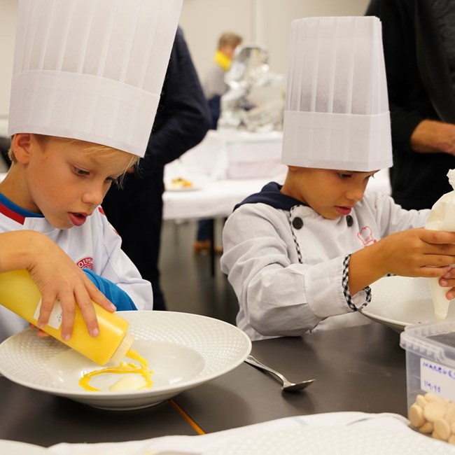Koncentrerede børn anretter desserter til workshop på Hotel- og Restaurantskolen under Kulturnatten 2022
