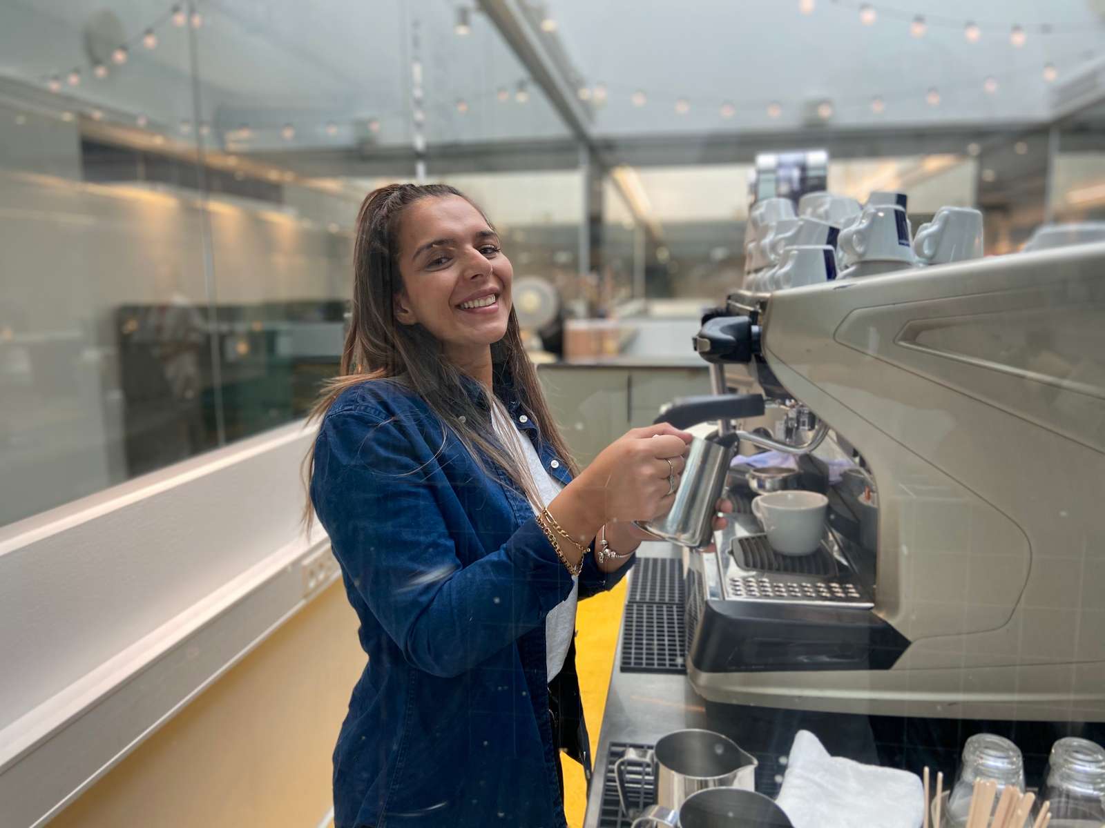 Receptionistelev laver baristakaffe i bar kaf.