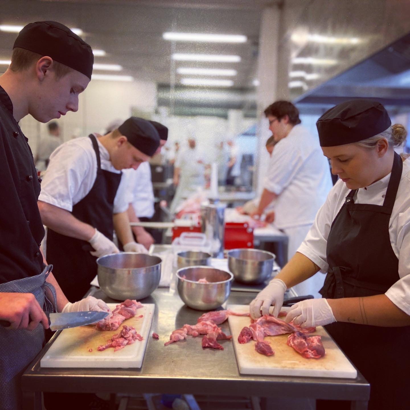 Slagterelever arbejder med udskæring af kød