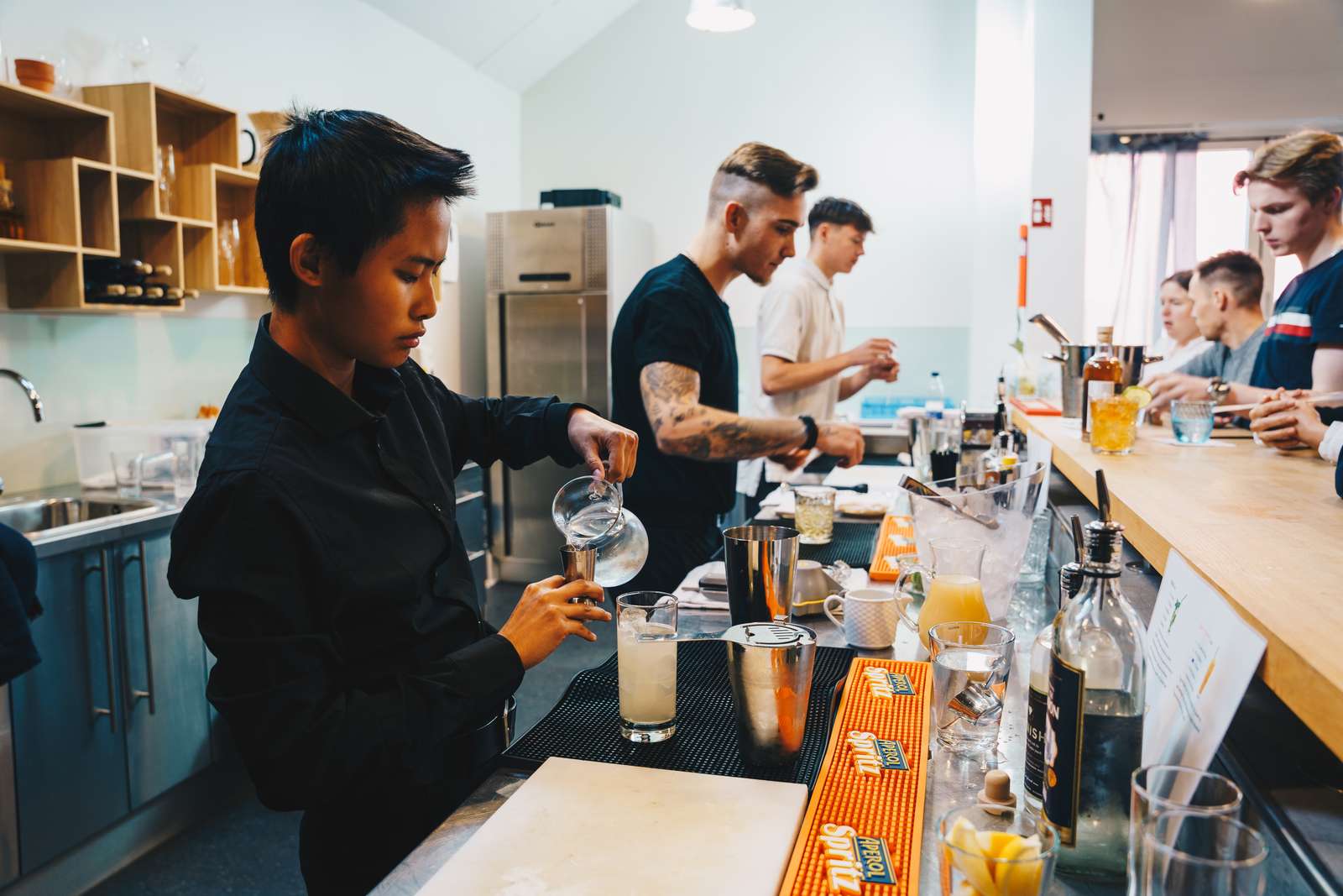 Tjenerelever laver cocktails.