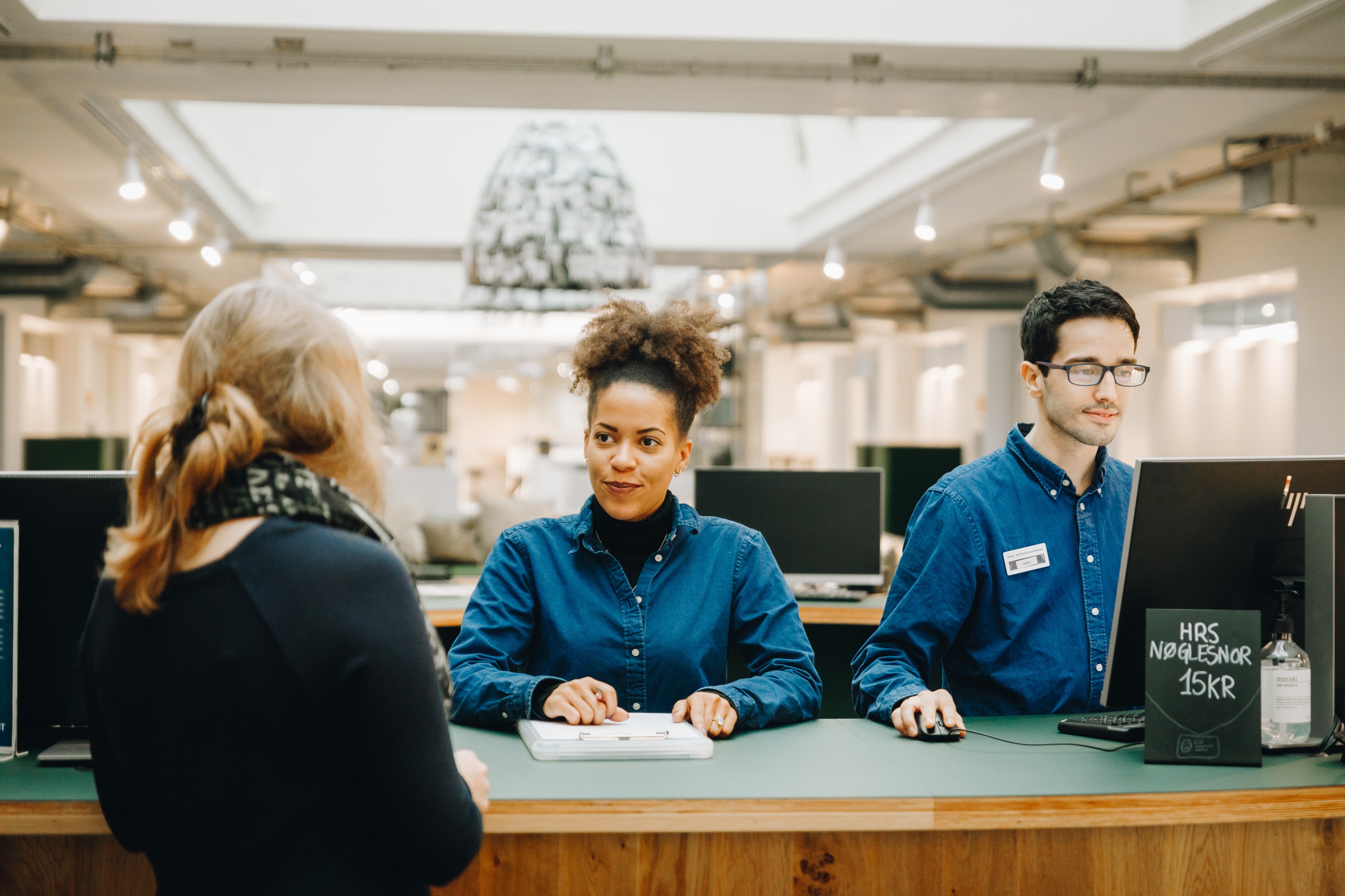 Receptionistelever arbejder i skolens lobby.