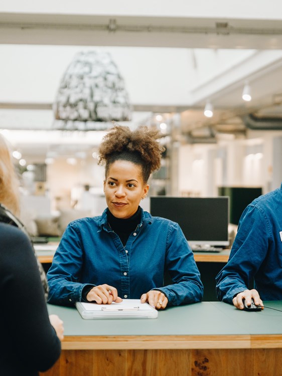 Receptionistelever arbejder i skolens lobby.
