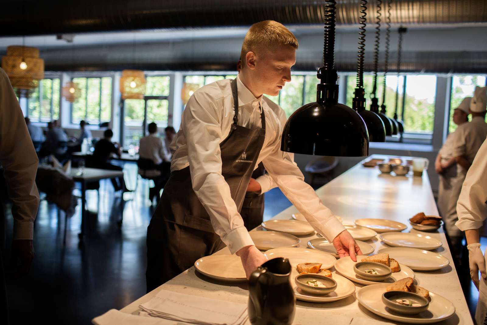 Tjenerelev gør klar til at servere i skolens restaurant.