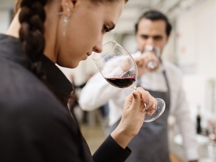 En kvinde dufter til rødvin på Hotel- og Restaurantskolen.