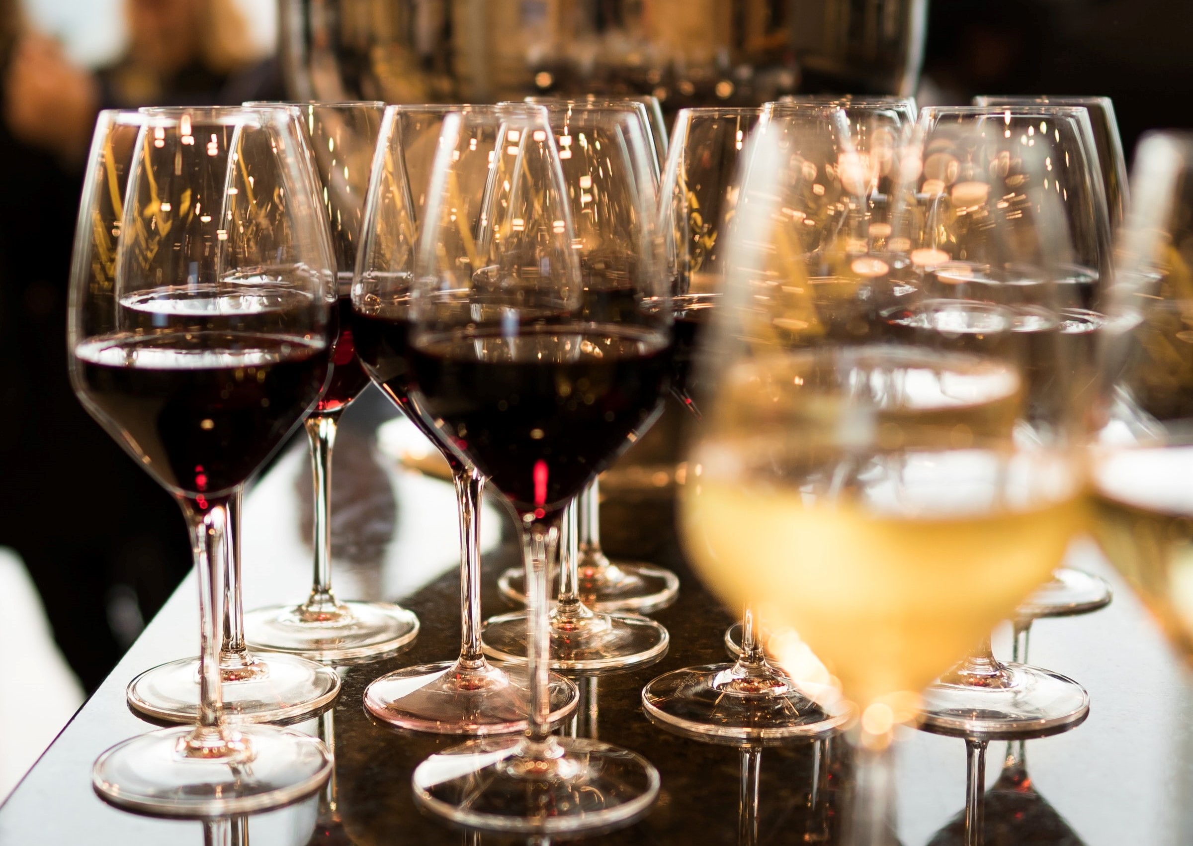 En række af glas med rødvin og hvidvin.