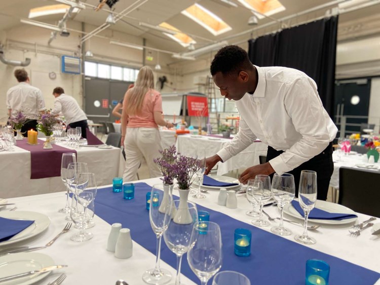 En tjenerelev gør klar til service.