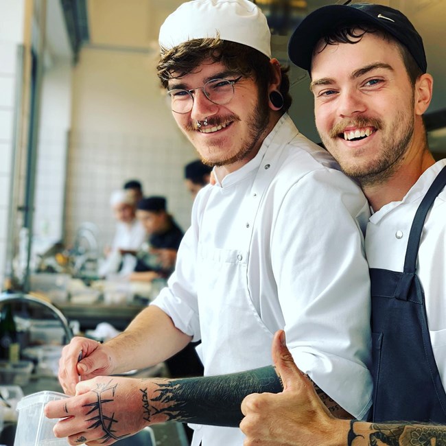 smilende mandlinge kokkeelever laver thumps up på Hotel- og Restaurantskolen